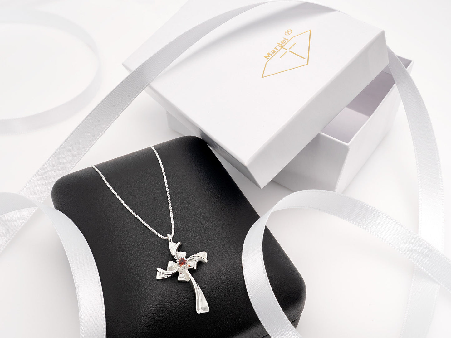 Red Garnet Silver Ribbon Cross Necklace. Handmade, sterling silver pendant with a natural, round faceted, garnet gem.