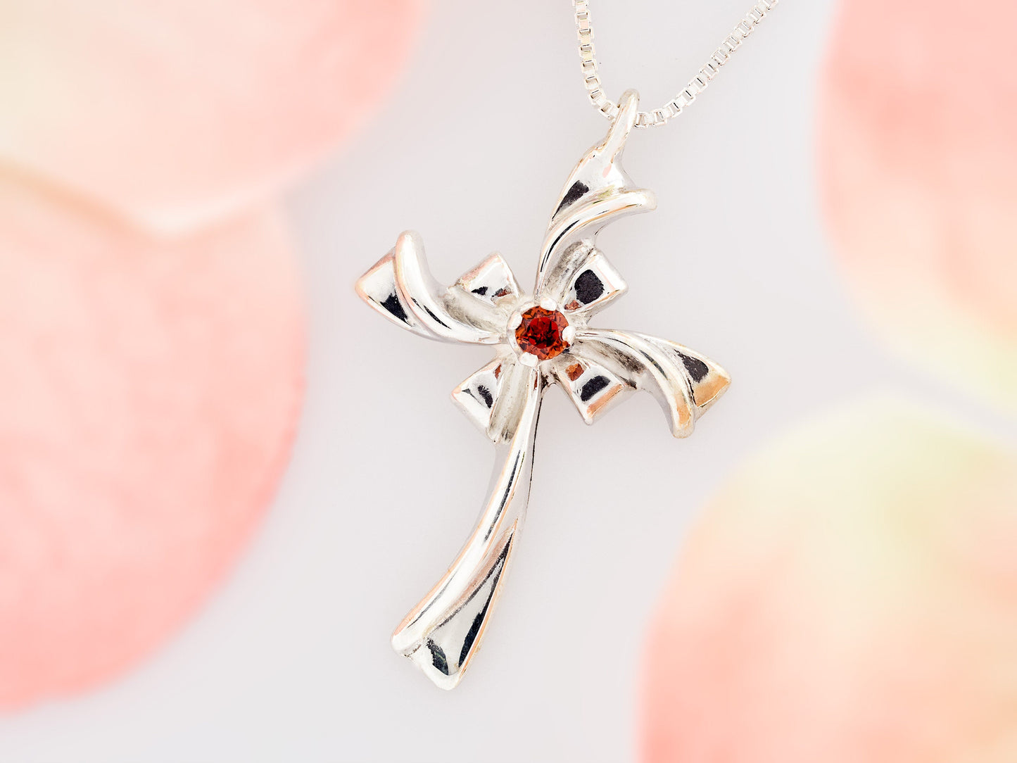 Red Garnet Silver Ribbon Cross Necklace. Handmade, sterling silver pendant with a natural, round faceted, garnet gem.